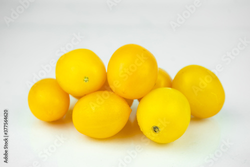 Batch of yellow fresh tomatoes isolated on white background