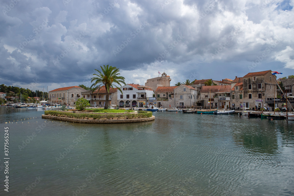 Vrboska/ Croatia-August 7th, 2020: Colorful houses at the end of the bay in town of Vrboska, with small islet in the sea