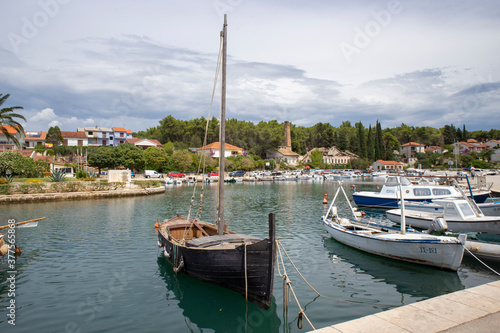 Vrboska/ Croatia-August 7th, 2020: Beautiful wooden boats in the bay of Vrboska town, and ruins of old factory across the channel