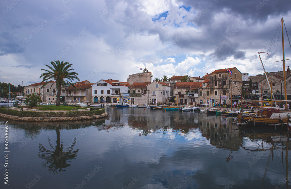 Vrboska, Croatia-August 7th, 2020: Colorful houses of Vrboska town, small place on the Hvar island located in deep, natural bay, used as port with small, round islet at the end