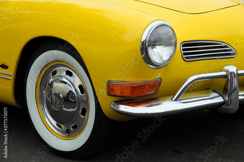 Front Grill and headlights of a vintage sprots car, bright yellow and chrome