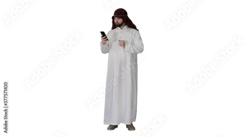 Arab man using his smartphone surfing on the internet or messaging on white background. photo