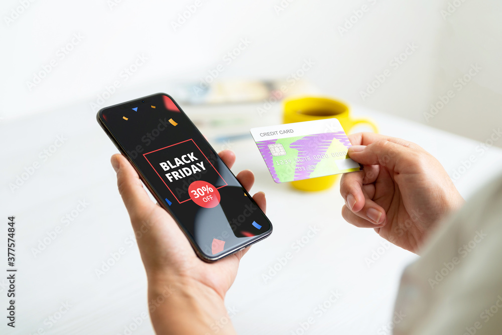 Fototapeta premium Black friday deal banner on smart phone. Woman holding credit card. Holiday online shopping concept