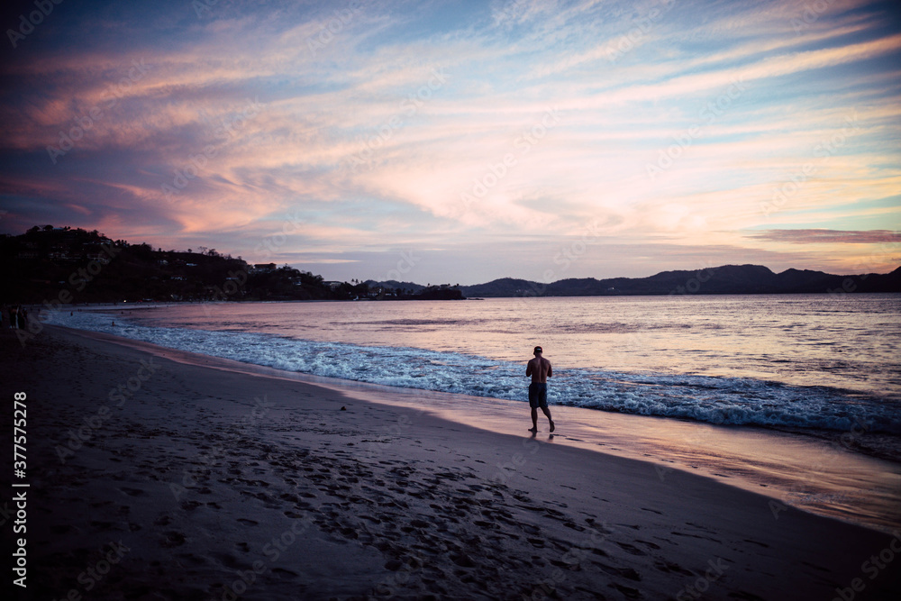 Beach, man walking on the beach, sunset, waves