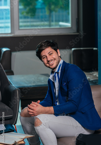 Portrait of a caucasian handsome young businessman talking to colleagues in a meeting room. photo