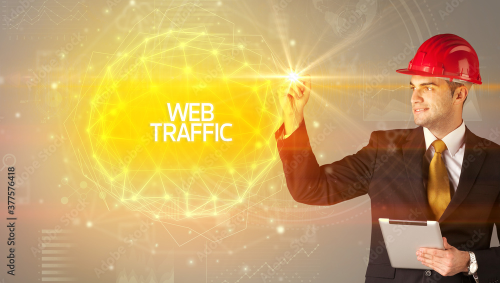 Handsome businessman with helmet drawing WEB TRAFFIC inscription, social construction concept Handsome businessman with helmet drawing WEB TRAFFIC inscription, social construction concept