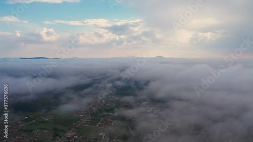 Aerial shot over the clouds and over the villages beneath. photo