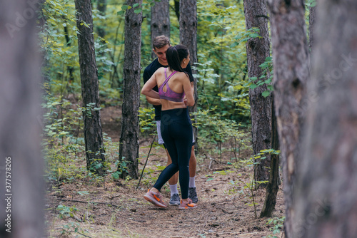 Fit male and female athletes running in nature. Nature and sports concept.