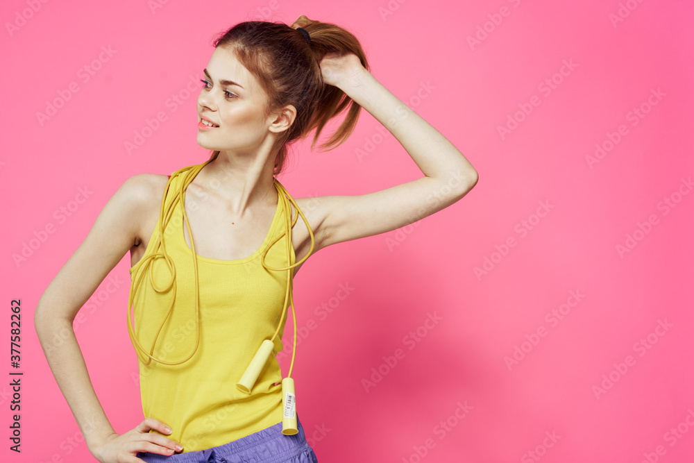 sportive woman jumping rope in hands yellow tank top pink background workout lifestyle sportive woman jumping rope in hands yellow tank top pink background workout lifestyle