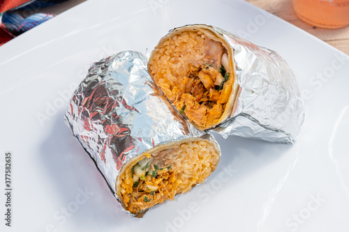 Delicious chicken burrito with rice, beans, cilantro, and vegetables. Mexican food from a food cart. 