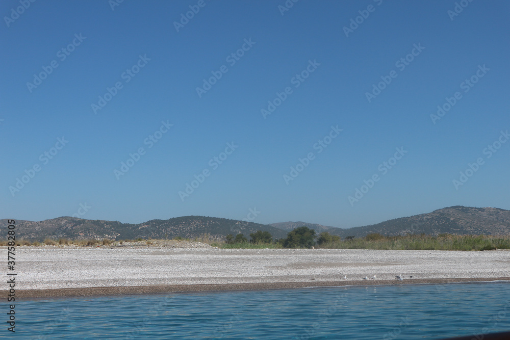 View of Fort from the Ocean. Still Waters with Cliffs. Still blue ocean waters with fort in the background distance. Cliff shores
