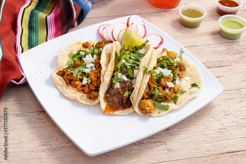 Fototapeta Naklejka Na Ścianę i Meble -  Fast and cheap Mexican street tacos. Carne asada, barbacoa, and chicken served on small and simple corn tortillas.