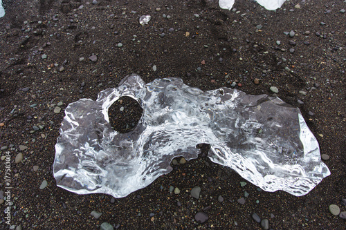 close up of a piece of ice on the black sand