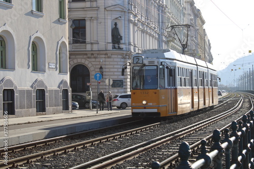 Yellow and white tram through the streets of Budapest