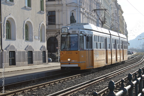 Yellow and white tram through the streets of Budapest