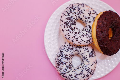 Pink sweet doughnuts on a white plate for tea, sweets