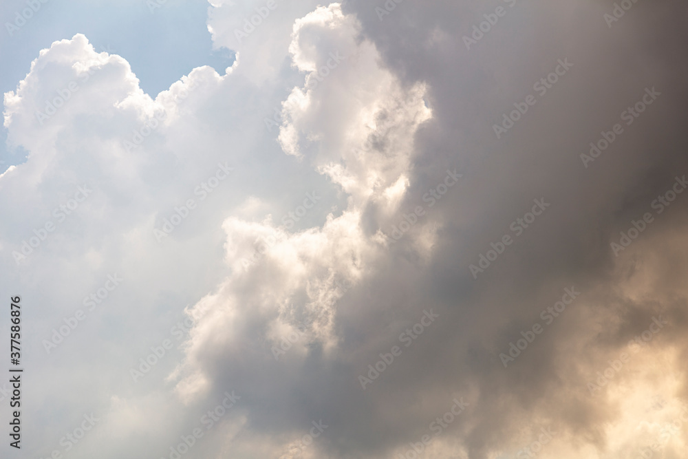 Fototapeta premium Looking up to moody clouds, weather is changing visibly in the sky and rain is on the way. sunlight is creeping through. Textured graphic design resource