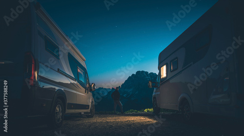 Alpine Camping Pitch and Men Between Two RVs Camper Vans
