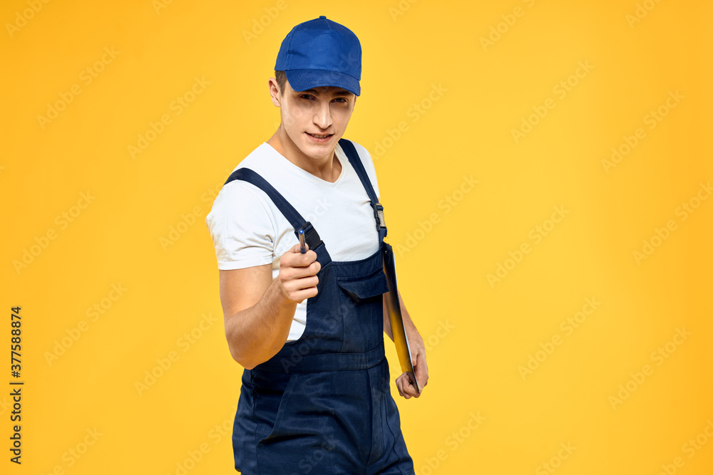 Man in working uniform documents rendering of services delivery service yellow background