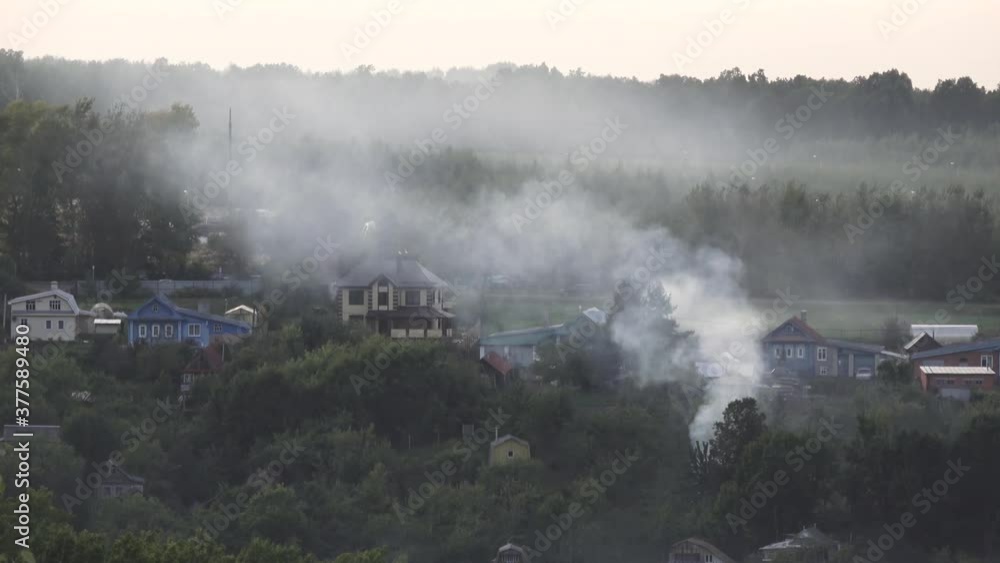 Evening smoke over a village in Russia. It spreads like a fog over the settlement. Evening smoke over a village in Russia. It spreads like a fog over the settlement.