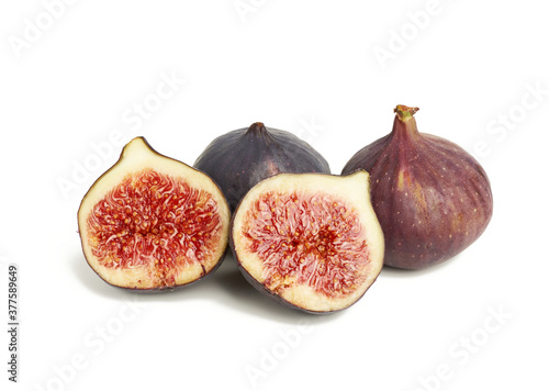 ripe whole and halved purple figs isolated on white background