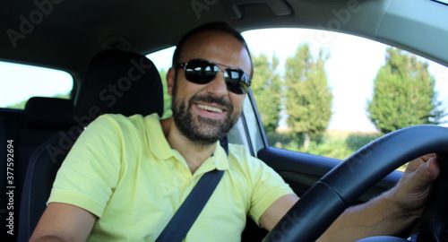Uomo che guida l'automobile e sorride