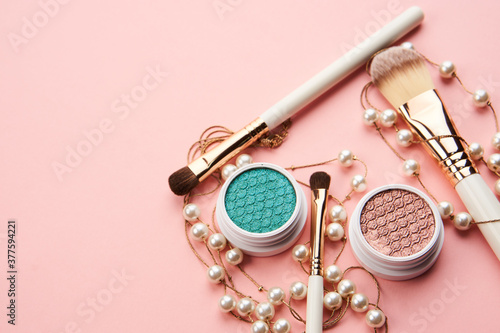 eyeshadow accessories beads makeup brushes collection professional cosmetics on pink background