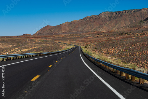 American roadtrip. Landscape with orange rocks, sky with clouds and asphalt road in summer.