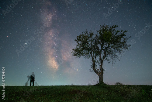 man and dogs under milky way and stars 