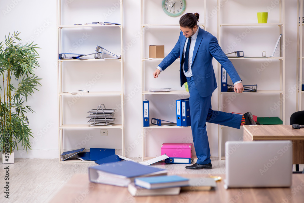 Young male employee unhappy with excessive work Young male employee unhappy with excessive work