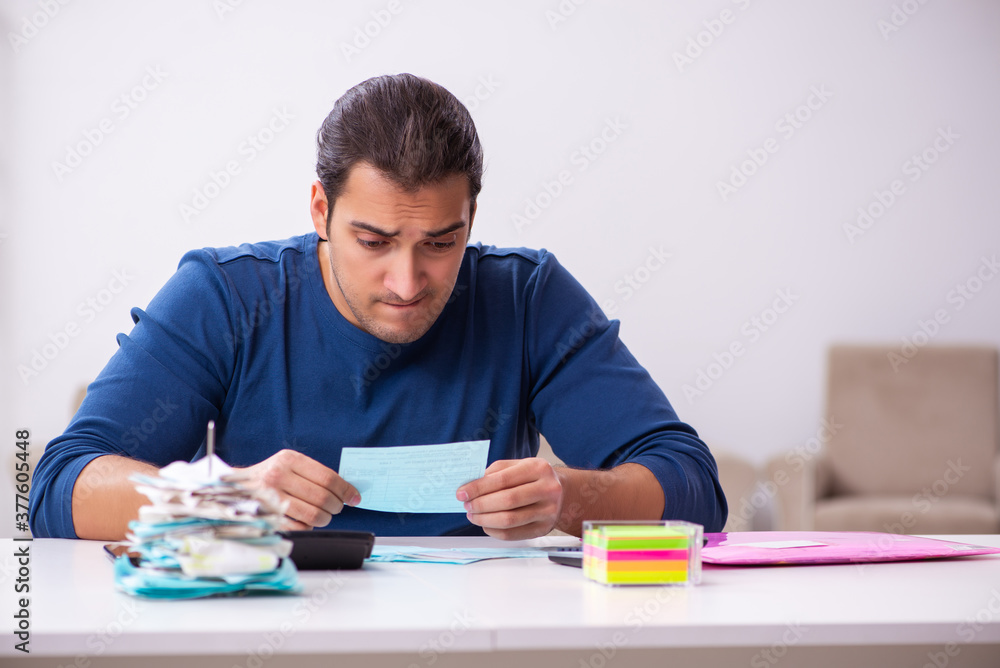 Young man in budget planning concept Young man in budget planning concept