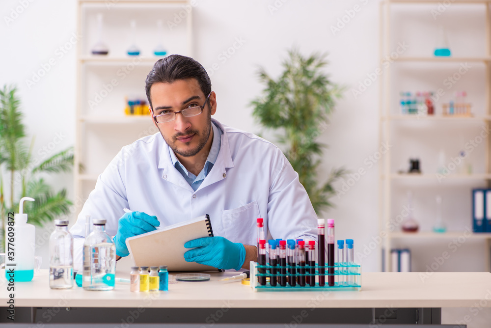 Young male chemist working in the lab Young male chemist working in the lab