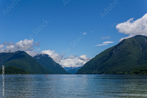 blue mountain lake with green mountains blue sky and white clouds
