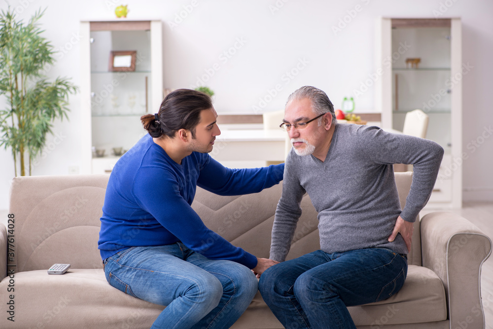Young man looking after his sick father Young man looking after his sick father