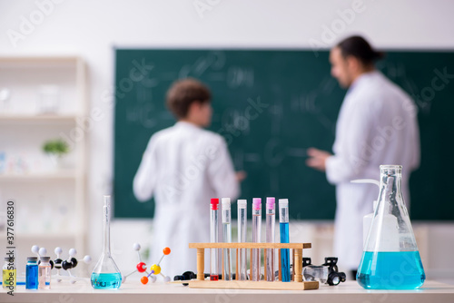 Young chemistry teacher and schoolboy in the classroom