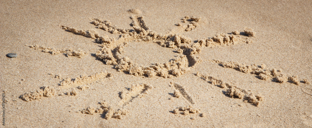 Shape of sun on sand at beach. Summer, vacation time and tourism Shape of sun on sand at beach. Summer, vacation time and tourism