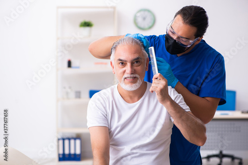 Billede på lærred Old man visiting young male doctor in hair transplantation conce