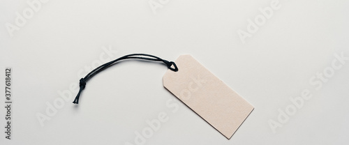 The price tag made of cardboard is empty without inscriptions on a light background.
