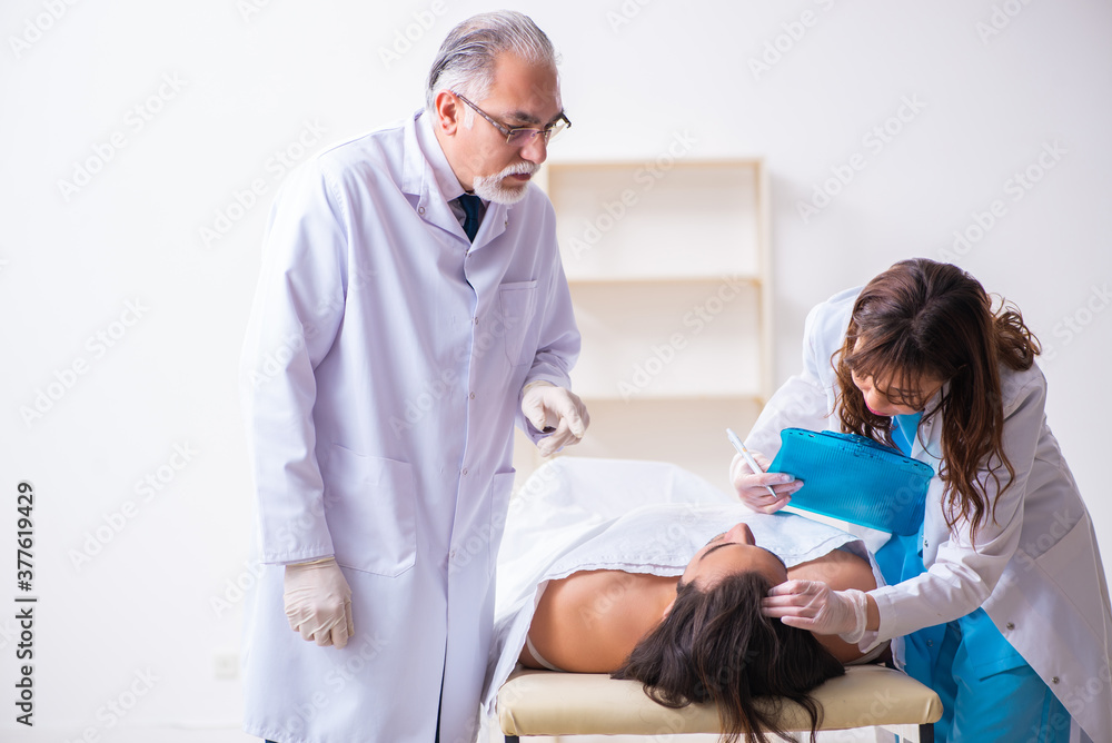 Fototapeta premium Police coroner examining dead body corpse in morgue