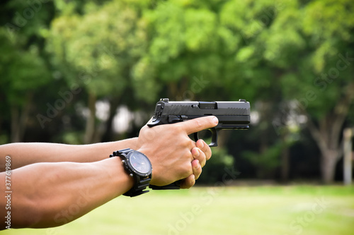Black short shooting gun in hand ready to shoot and after shooting.