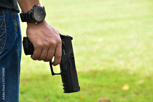 Black short shooting gun in hand ready to shoot and after shooting.