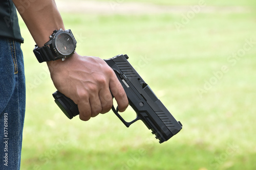 Black short shooting gun in hand ready to shoot and after shooting.