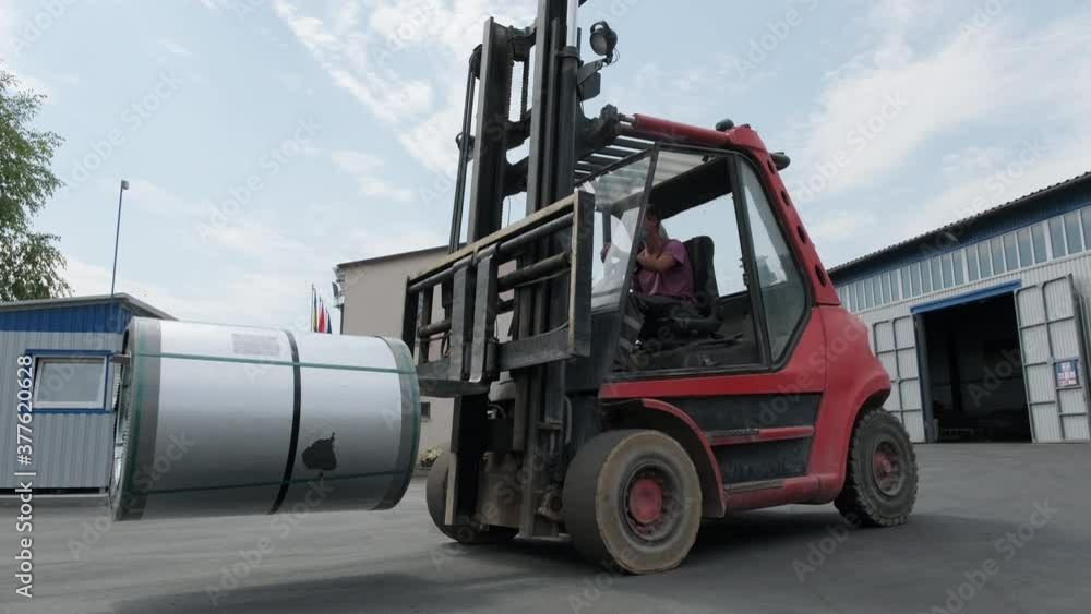 Forklift driver loads Rolls of steel sheet. Industrial warehouse with rolls of steel sheet Forklift driver loads Rolls of steel sheet. Industrial warehouse with rolls of steel sheet