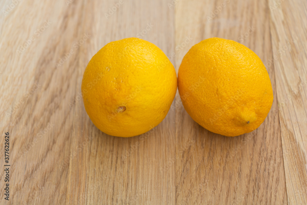 Two juicy lemons on wooden background. The benefits of lemon Two juicy lemons on wooden background. The benefits of lemon