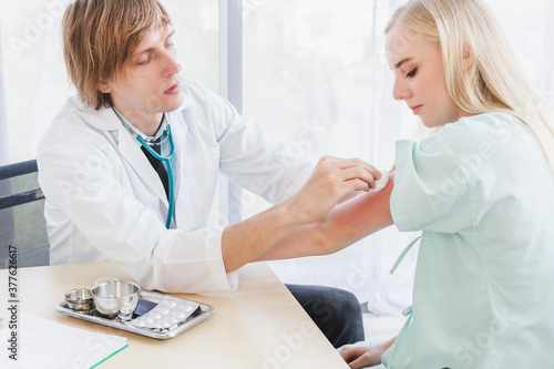 A doctor disinfects on arm's skin before injection