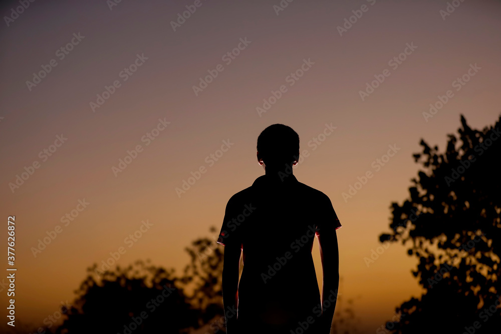 child silhouette on sunset background