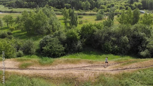 A man in sportswear runs in the park. Drone shooting. Outdoor sports.