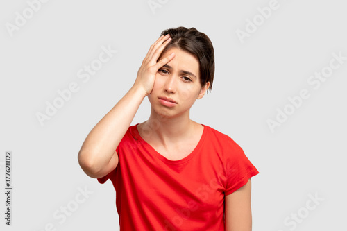 Wallpaper Mural Exhausted woman portrait. Headache frustration. Tired lady holding head by hand. Looking at camera isolated on neutral copy space. Feeling despair. Disappointment regret. Negative emotion Torontodigital.ca