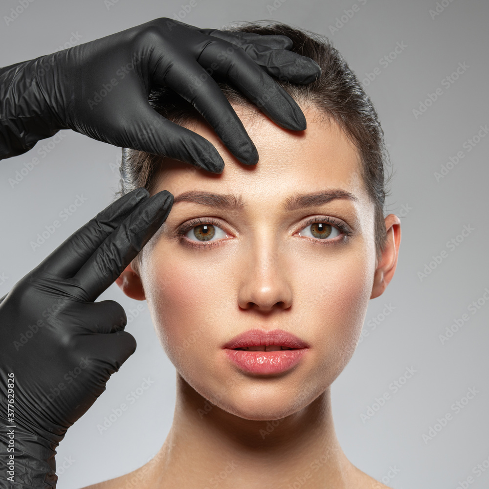 Face skin check before plastic surgery. Beautician touching woman face