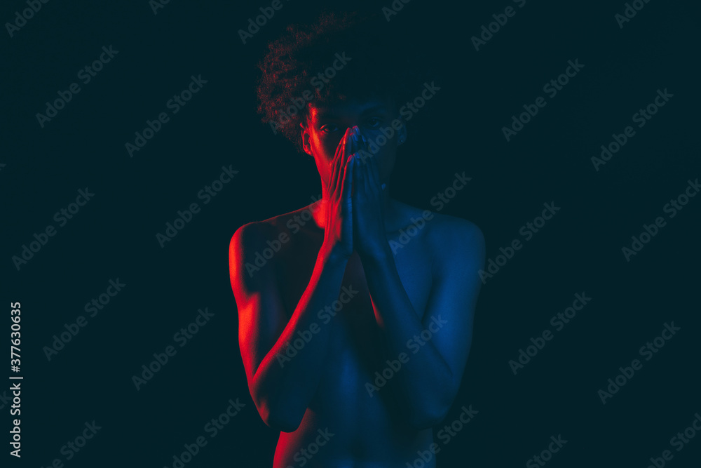 Black lives matter. Ethnic problems. Disappointed african male with shirtless torso closing mouth hands isolated on dark copy space. Human tolerance. No racism. Neon light silhouette - obrazy, fototapety, plakaty 